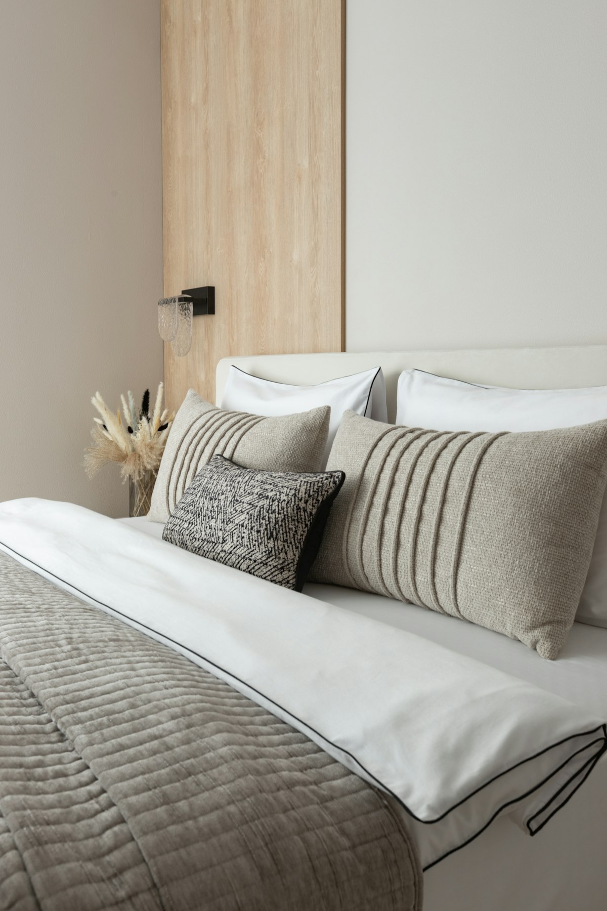 Neutral-toned bed with layered pillows and bedding