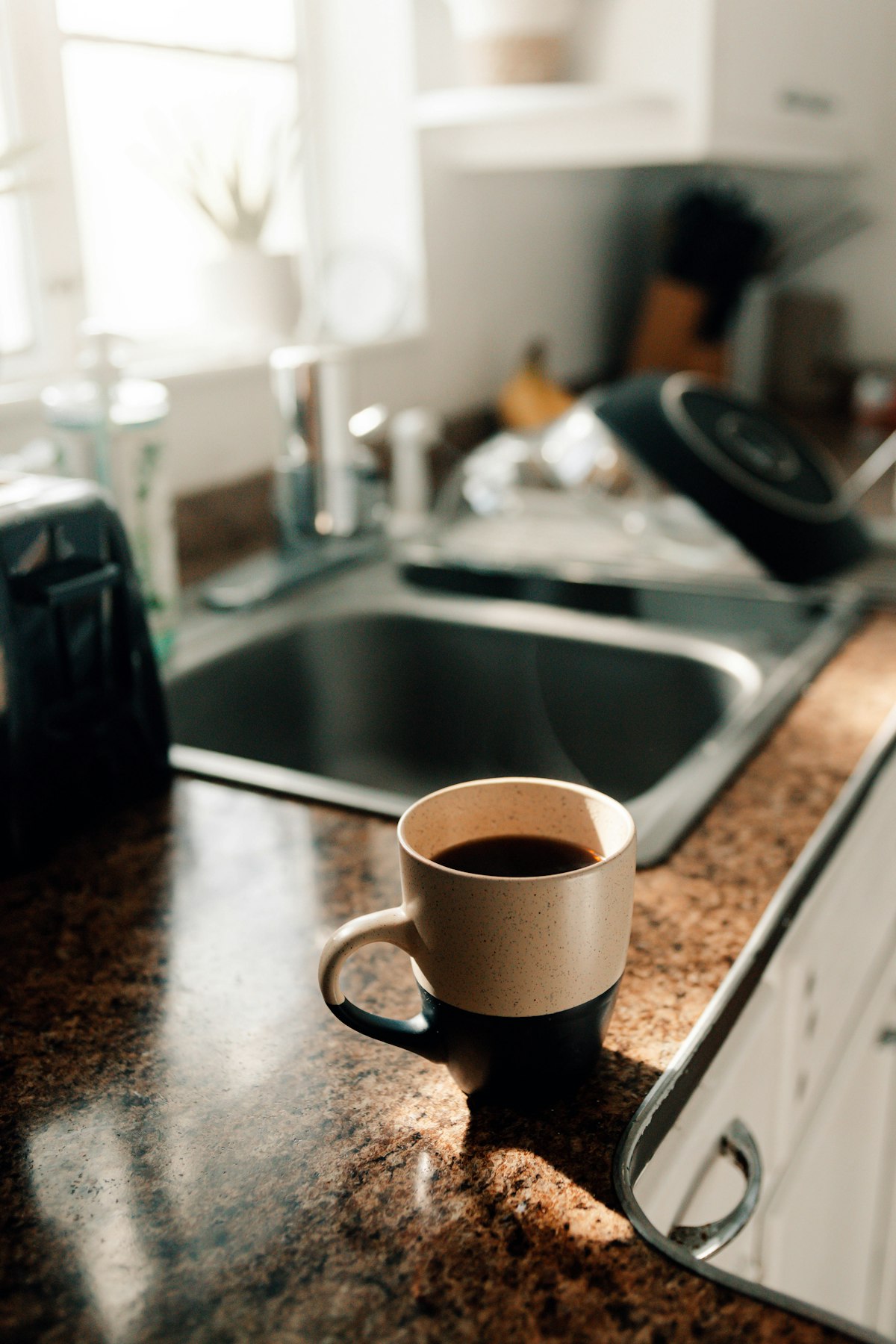 Kitchen sink and counter with a coffee cup in morning light